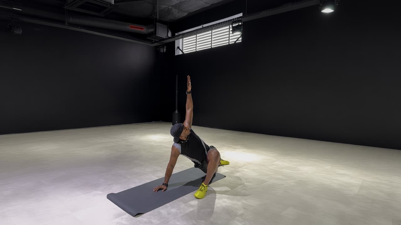 Laurent LABECA réalisant un exercice de mobilité sur un tapis dans une salle