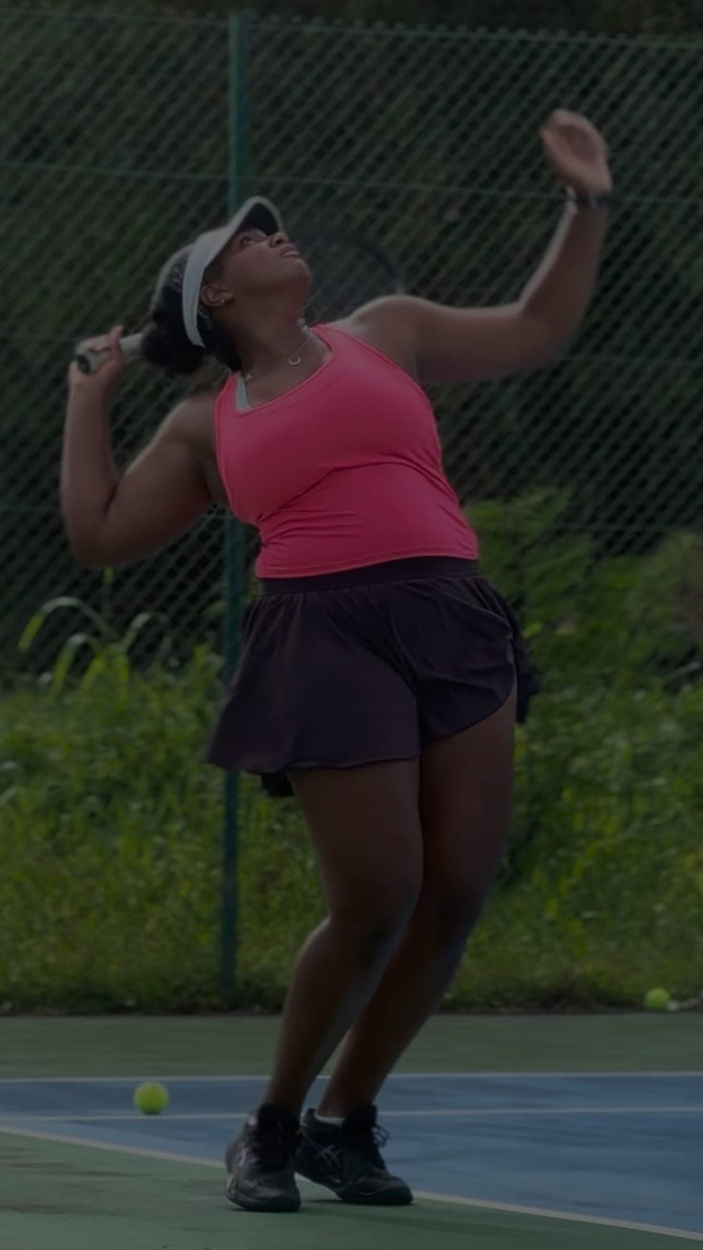 Service au tennis sur un court extérieur