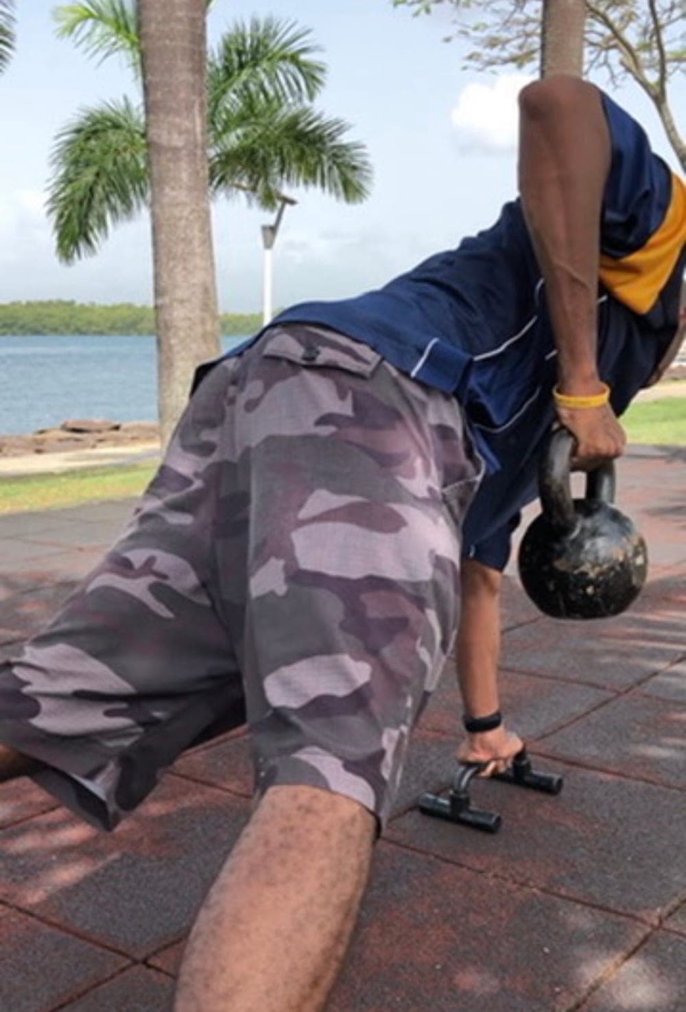Pompes sur poignées et travail de kettlebell en bord de mer