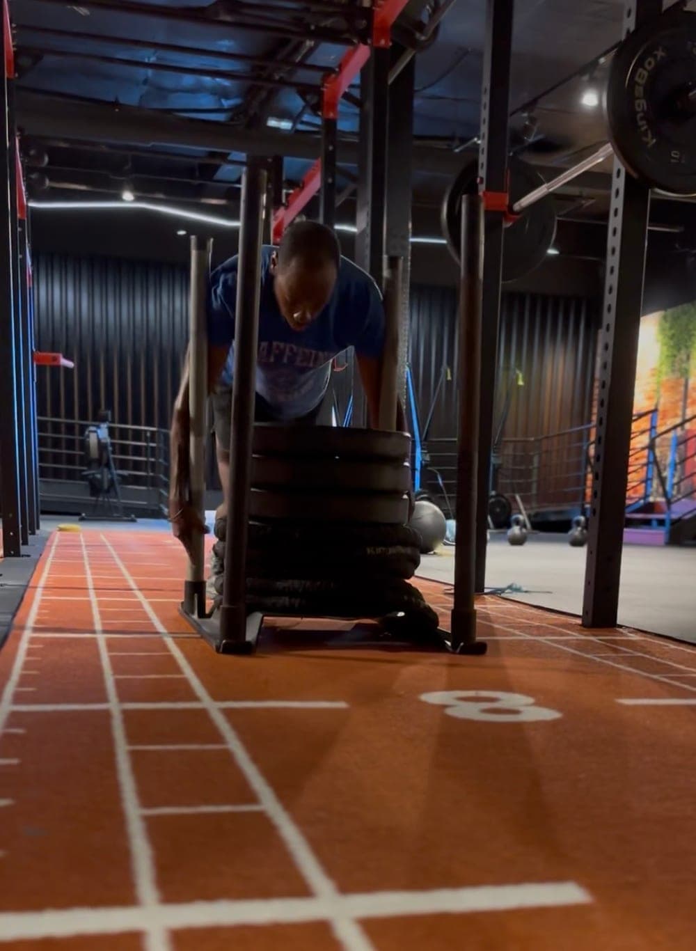Poussée de traîneau chargé sur la piste d’une salle d’entraînement