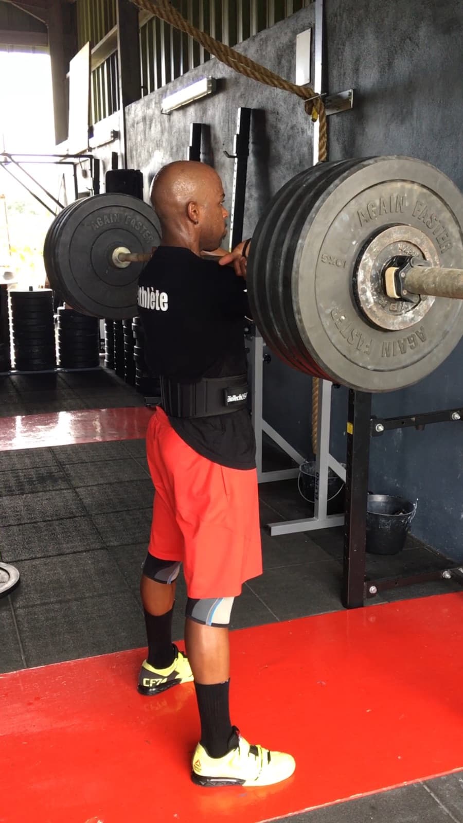 Laurent LABECA réalisant un épaulé avec une barre chargée en salle de CrossFit