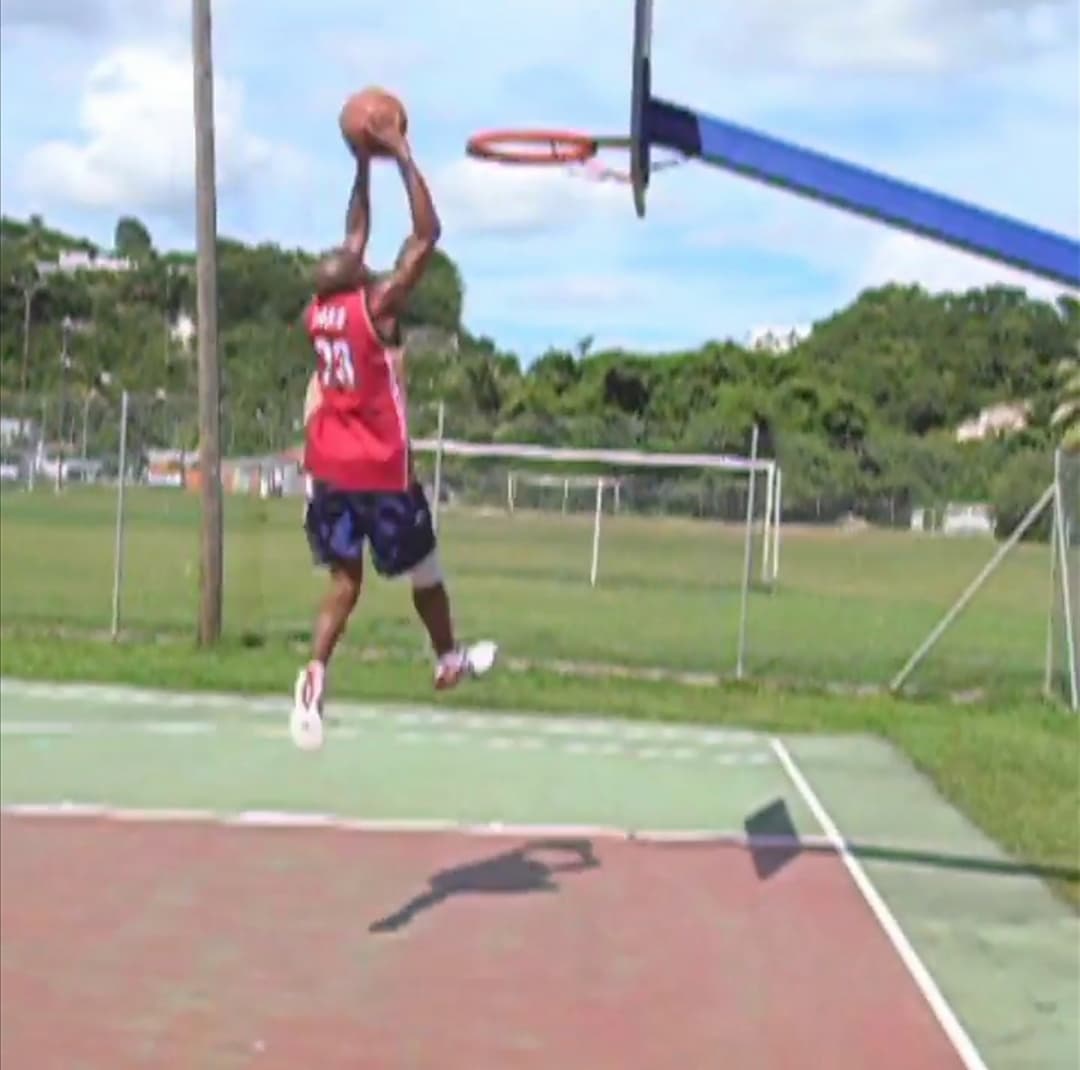 Laurent LABECA en extension vers le panier sur un terrain de basket en Guadeloupe